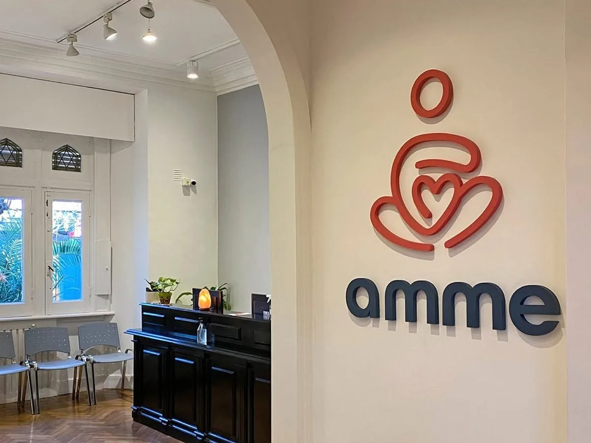 Recepción de AMME Salud, con el logo del centro en la pared y la sala de espera detrás del arco